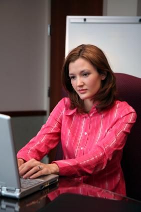 امرأة تكتب على جهاز الكمبيوتر المحمول الخاص بها.