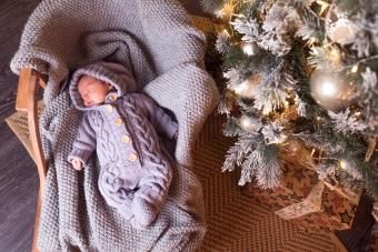 Menino dormindo embaixo da árvore de Natal