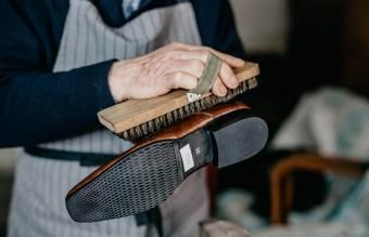 Sapateiro velho está engraxando um sapato
