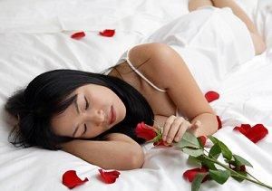 新娘躺在铺满玫瑰花瓣的床上