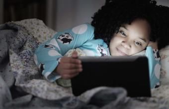 dievča pomocou digitálneho tabletu v posteli