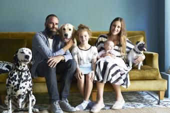Família sentada no sofá com seus cachorros