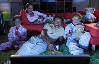Família assistindo tv e rindo