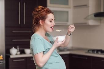 Бременна жена, която яде зърнени храни