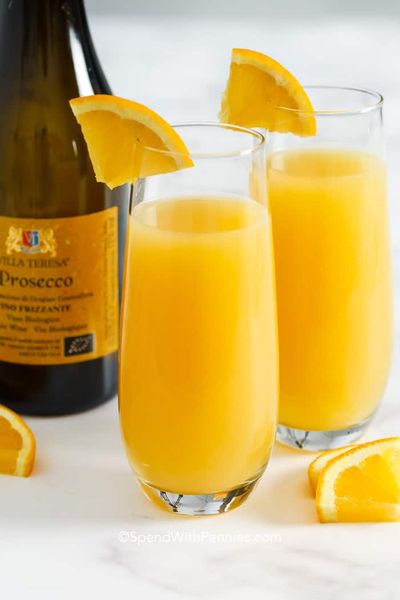 Duas mimosas em copos com fatias de laranja