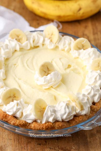 uma torta de creme de banana coberta com chantilly e bananas