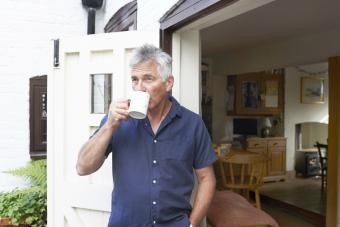 رجل ناضج يشرب الشاي في مدخل منزله