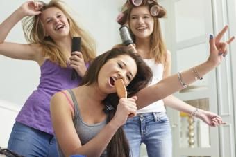 Meninas adolescentes cantando em escovas de cabelo