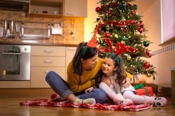 Opatrovateľka sa hrá s dieťaťom pri vianočnom stromčeku